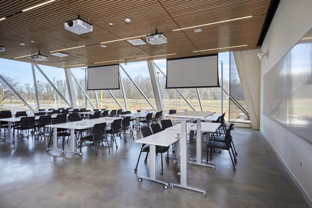 Professional cleaner in blue uniform in school hallway